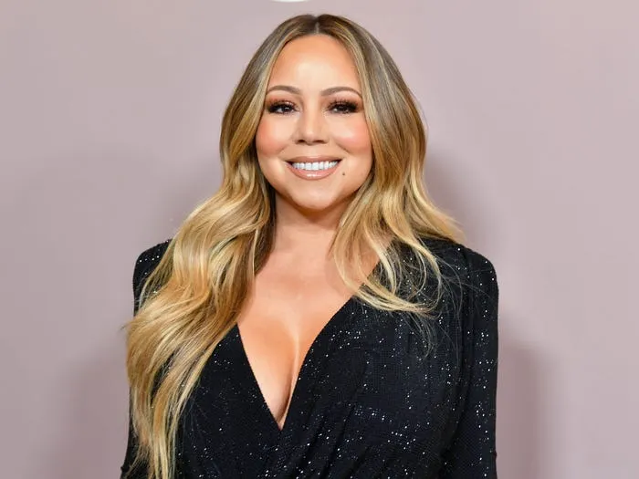 Mariah Carey a purtat o rochie specială de Crăciun! A avut nevoie de 6 bărbați să-i care trena pe scări